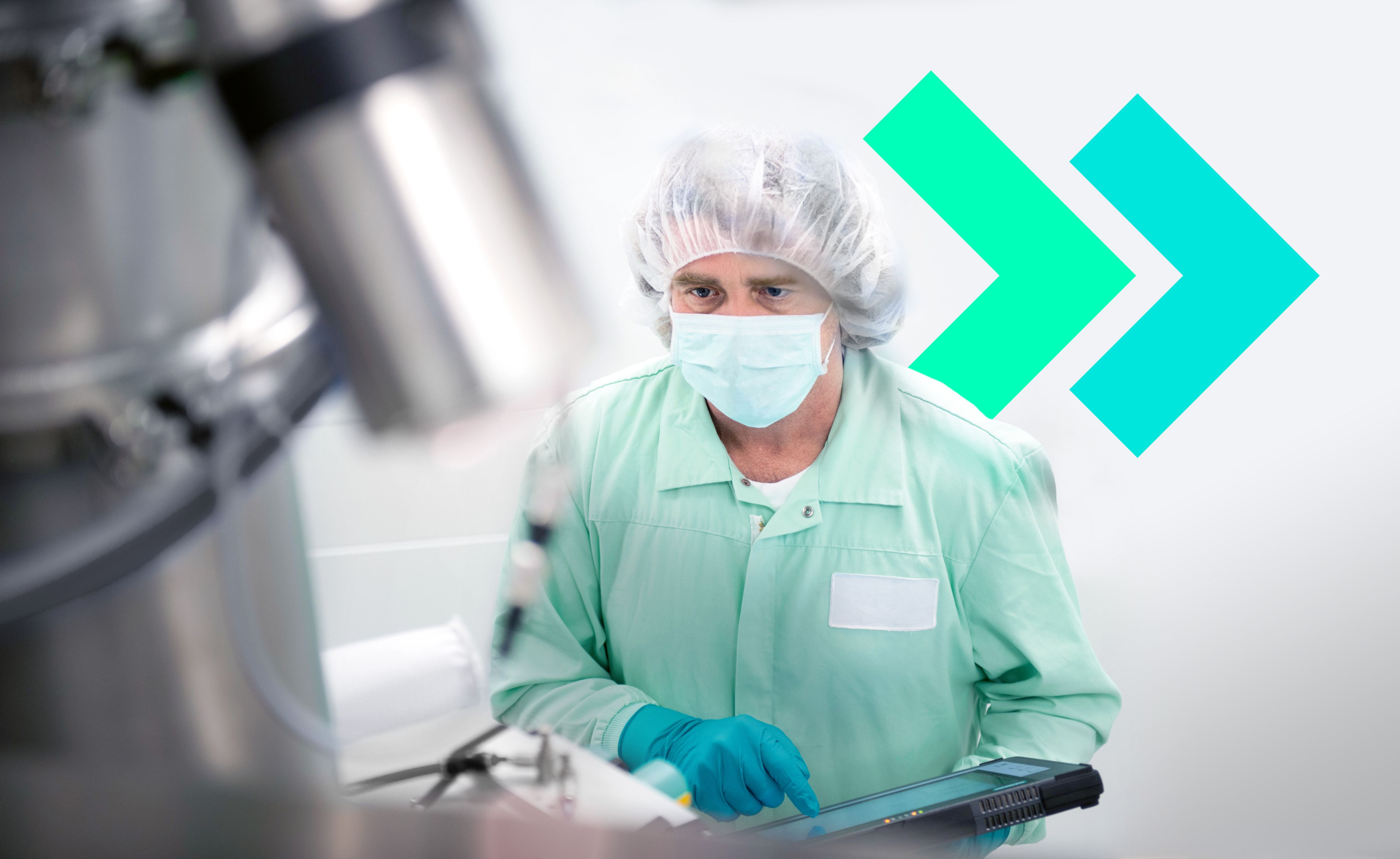 Person in cleanroom attire, mask and gloves operating equipment, with blurred machinery and teal arrows behind.