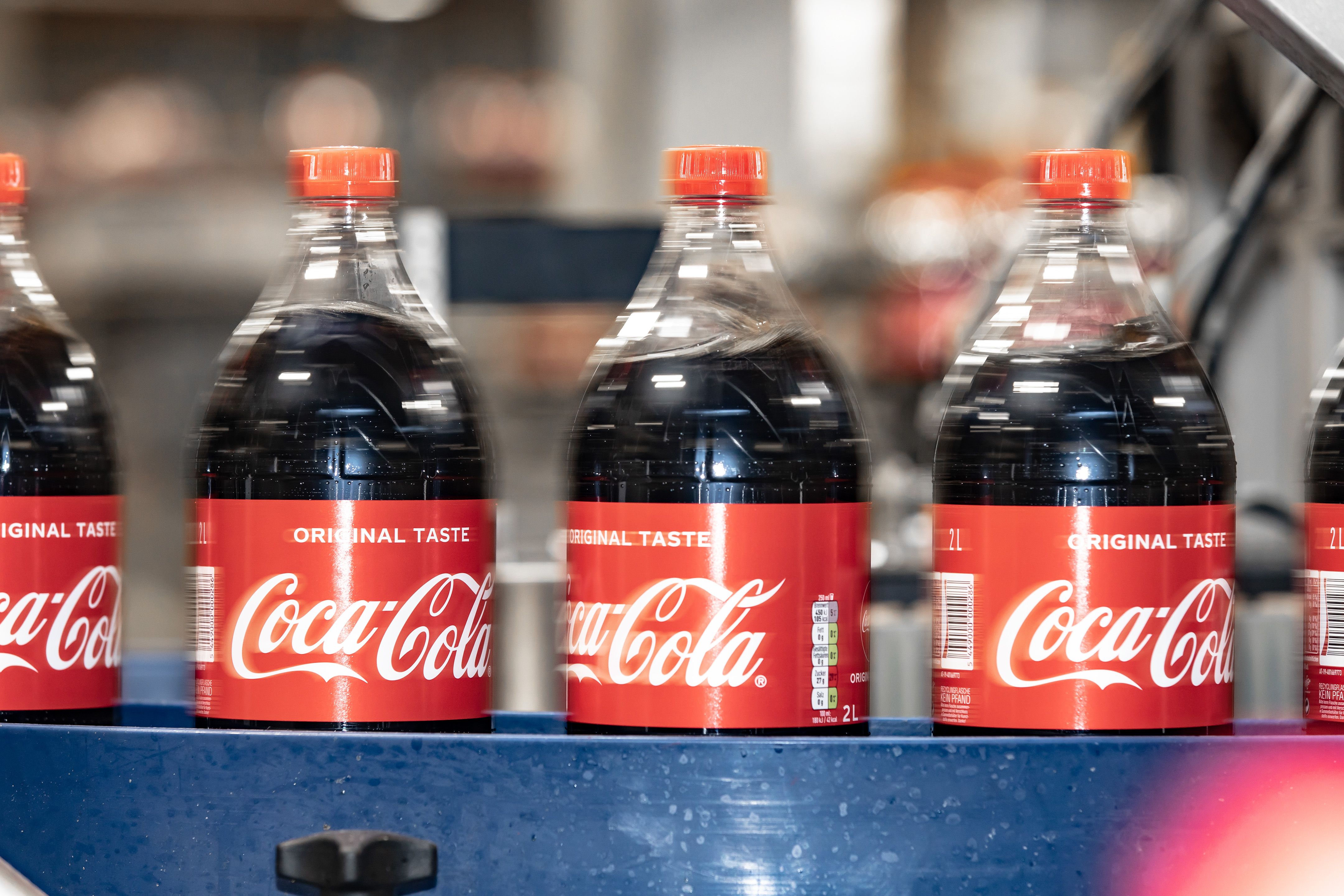 Chai Coca-Cola đi ngang qua băng tải