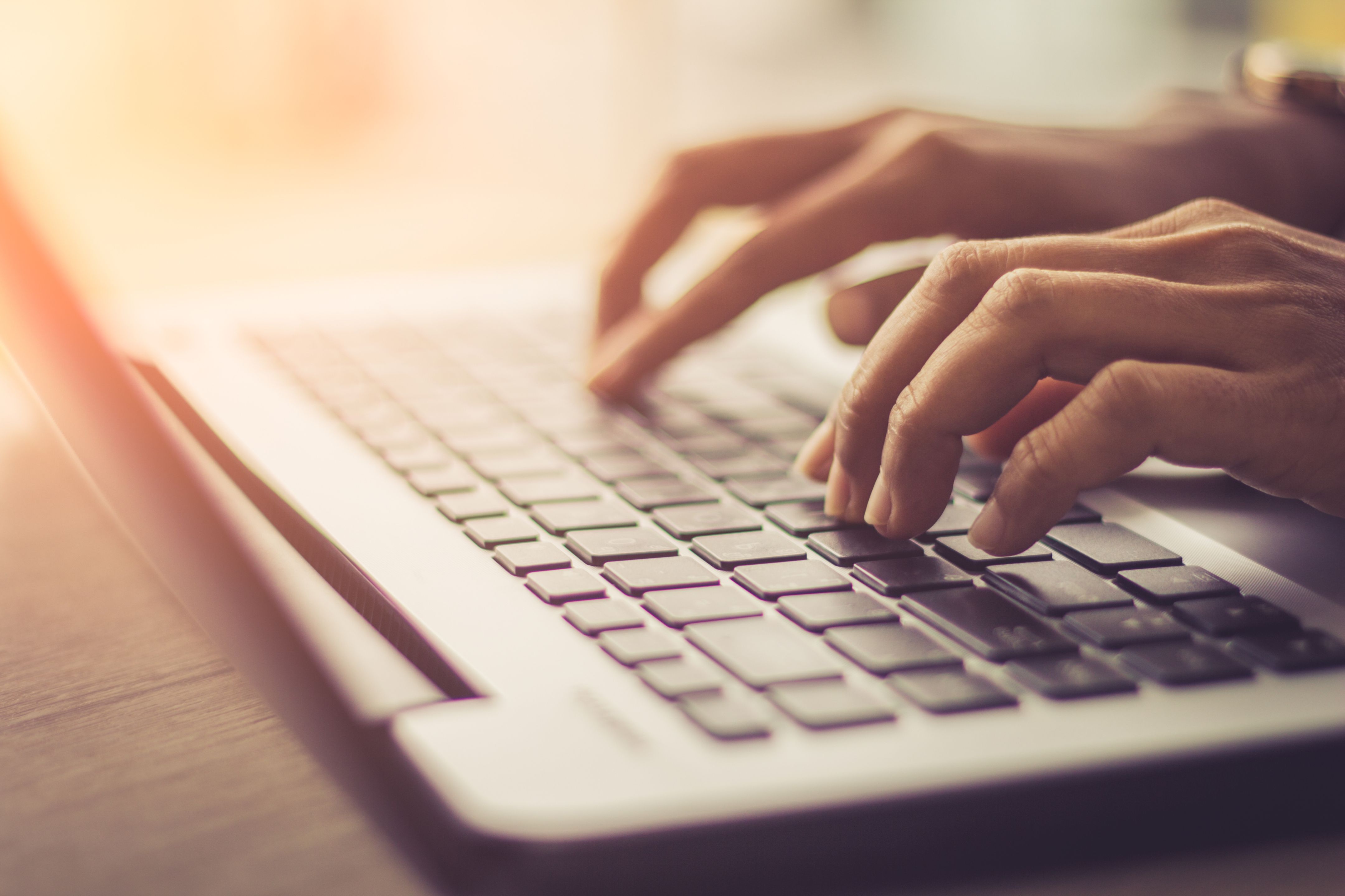  Osoba pisze obiema rękami na klawiaturze laptopa