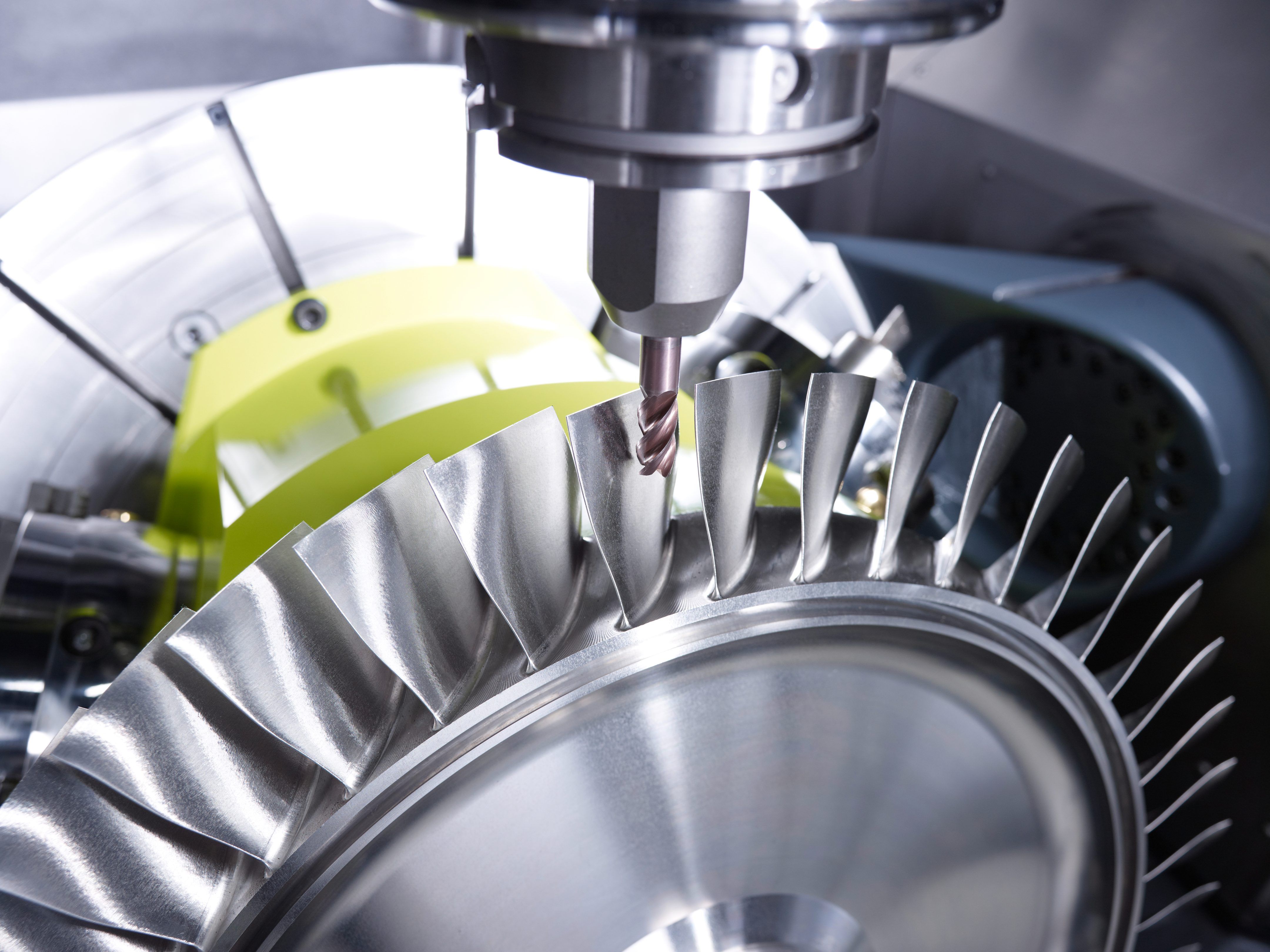 CNC milling of a turbine blade disc, with a drill bit cutting into the precision-machined metal component.