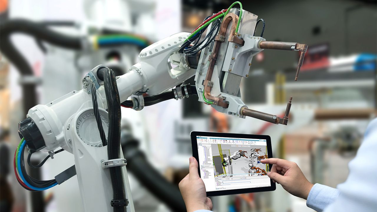 Számítógépet használó személy a robotkar 3D modelljével a képernyőn.
