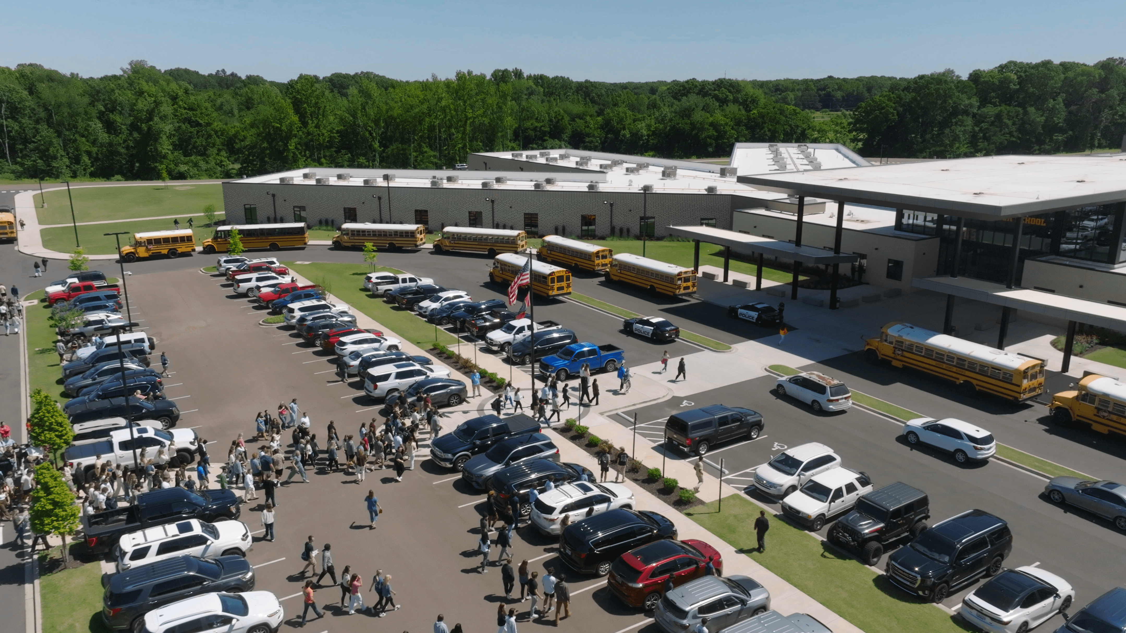 Birds-eye view of Hernando HS Entrance with students, cars, and buses