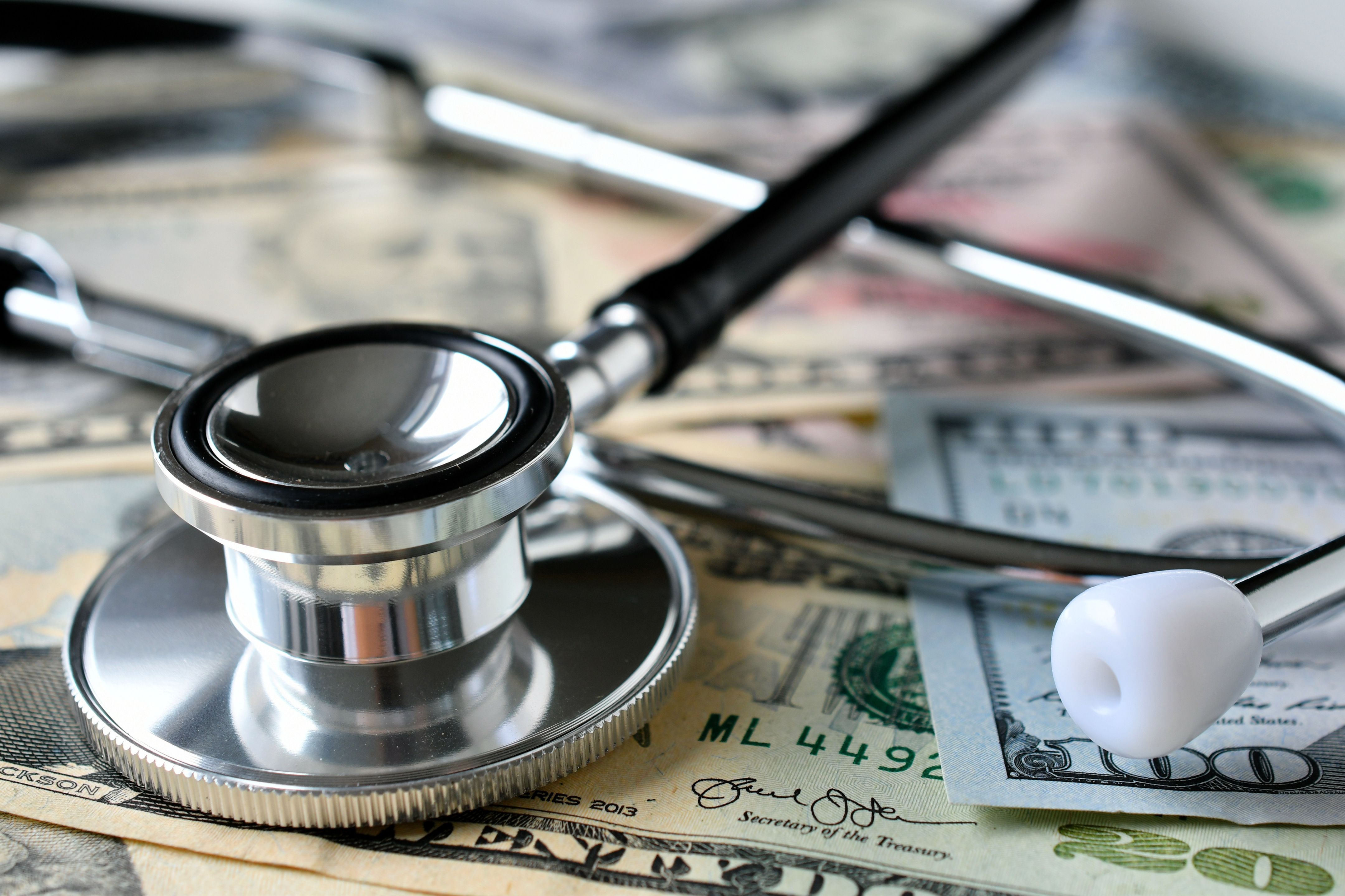 A stethoscope sitting on top of several US currency.