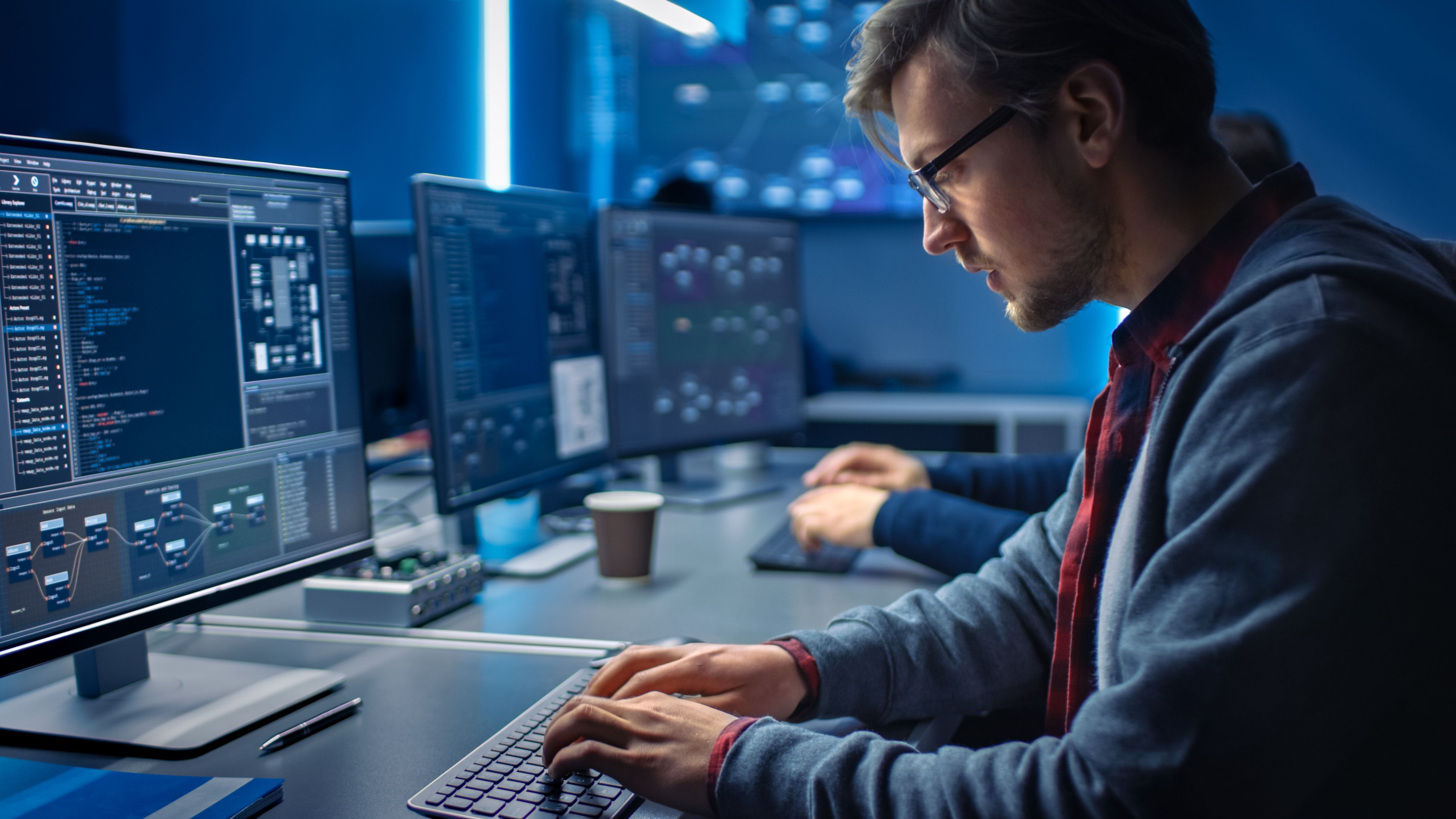 Szoftverfejlesztő programozás, Solutions keresése asztali számítógépeken végzett munka közben az adatközpont rendszervezérlőhelyiségében. A csúcstechnológiás kódolást végző fiatal szakemberek csapata