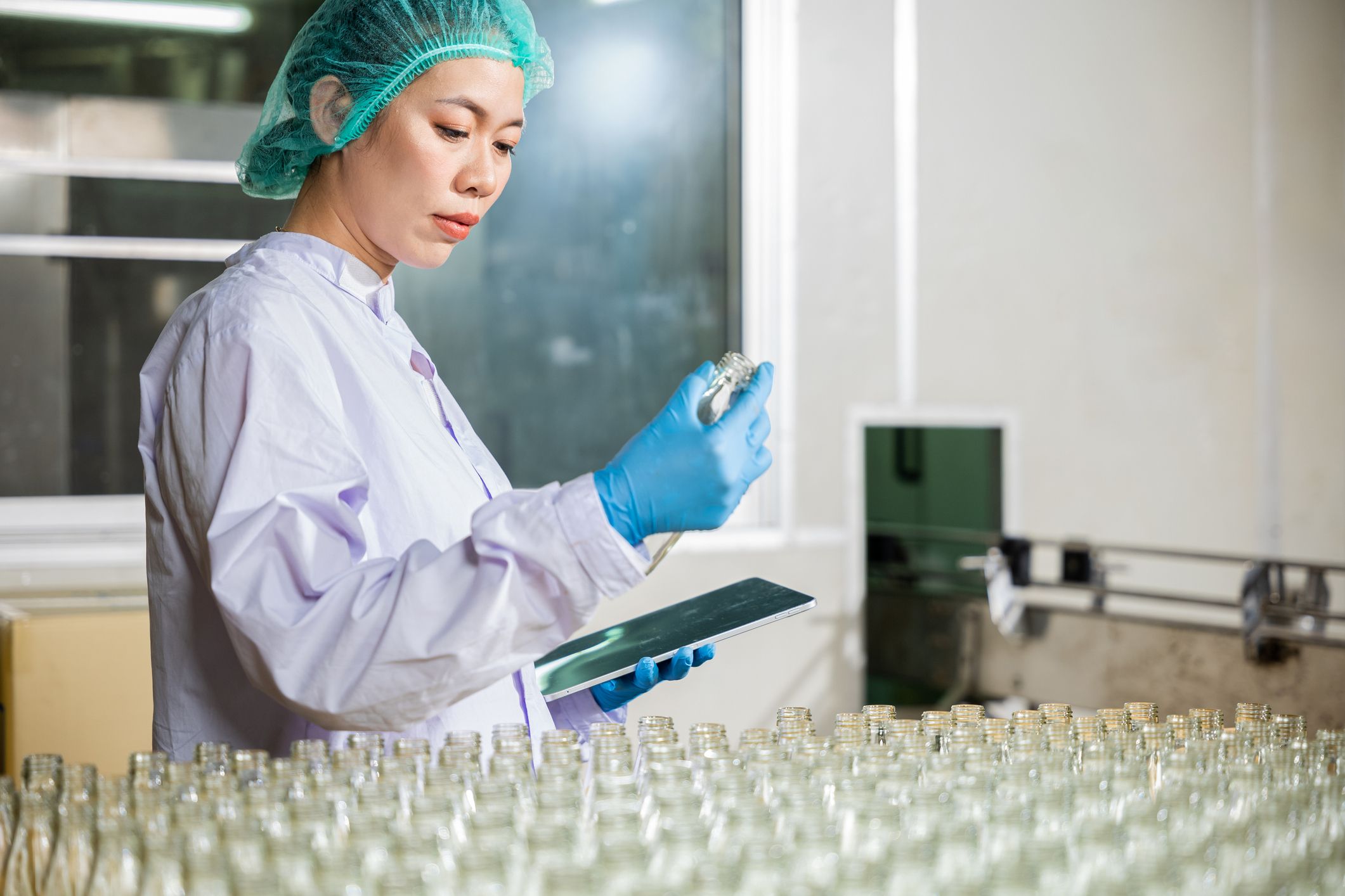 image of woman holding tablet and bottles