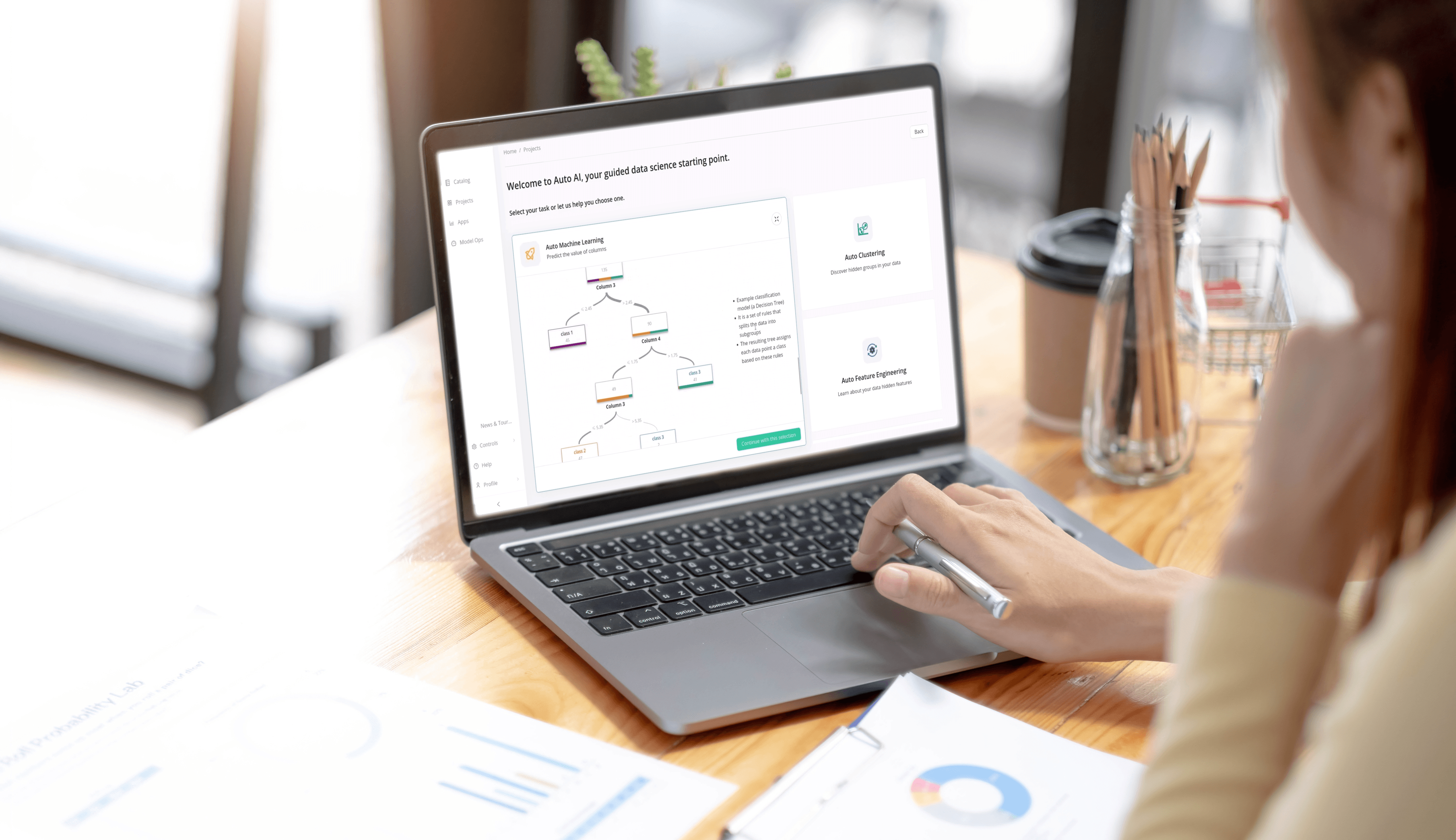 Egy személy hátulról látható, aki egy laptopon dolgozik, amely „Auto AI” adattudományi felületet jelenít meg egy döntési fa diagrammal