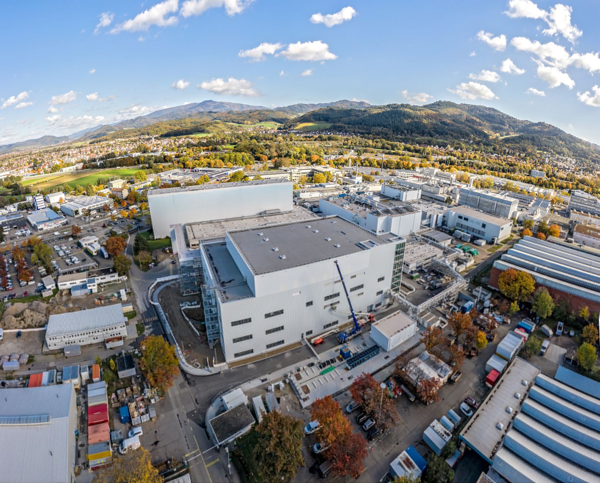 Arial kilátás a Pfizer-Werkre a Freiburgi campuson, hegyekkel a háttérben