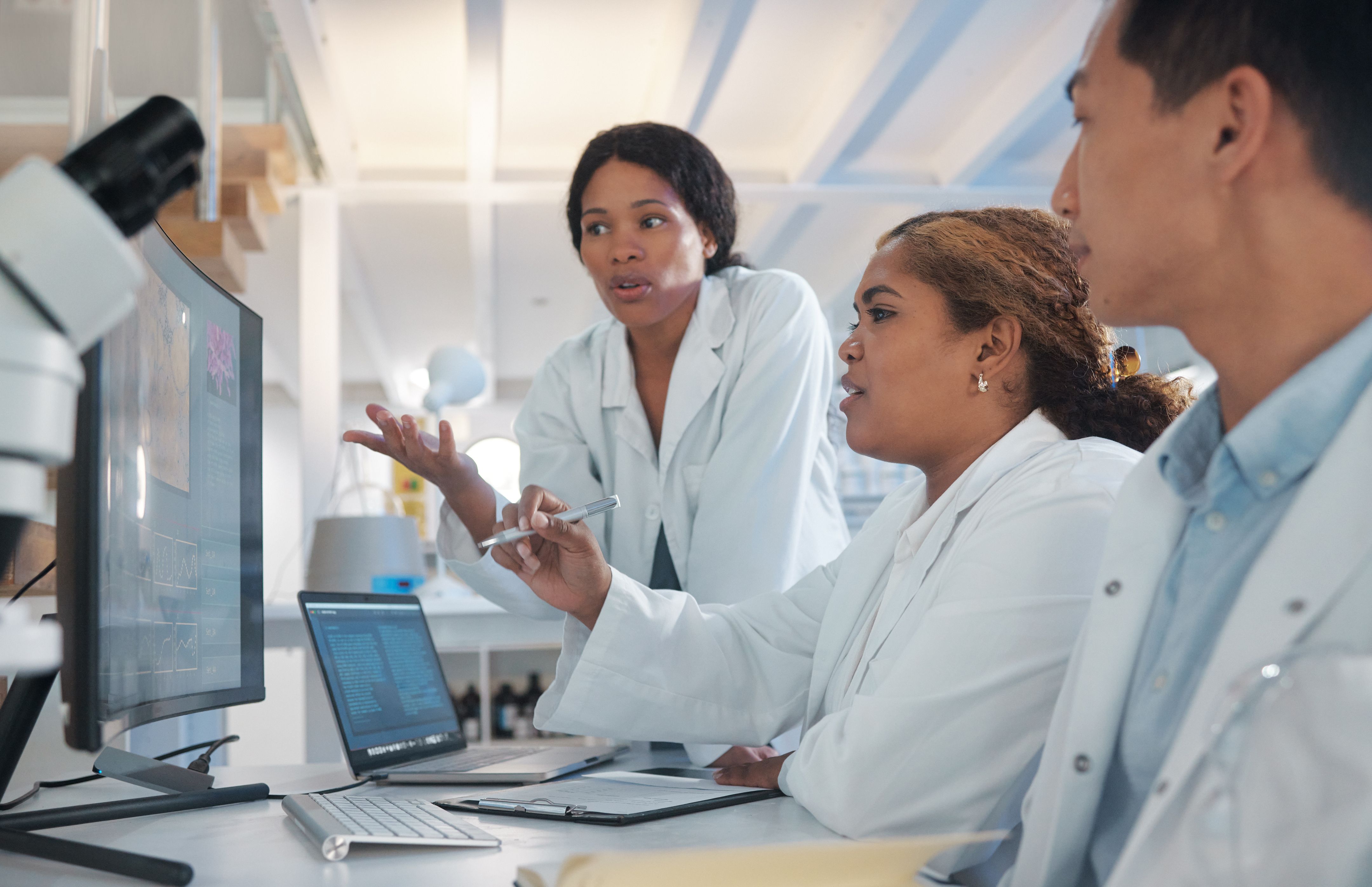Shot of a group of lab workers brainstorming ideas in front of a computer screen.