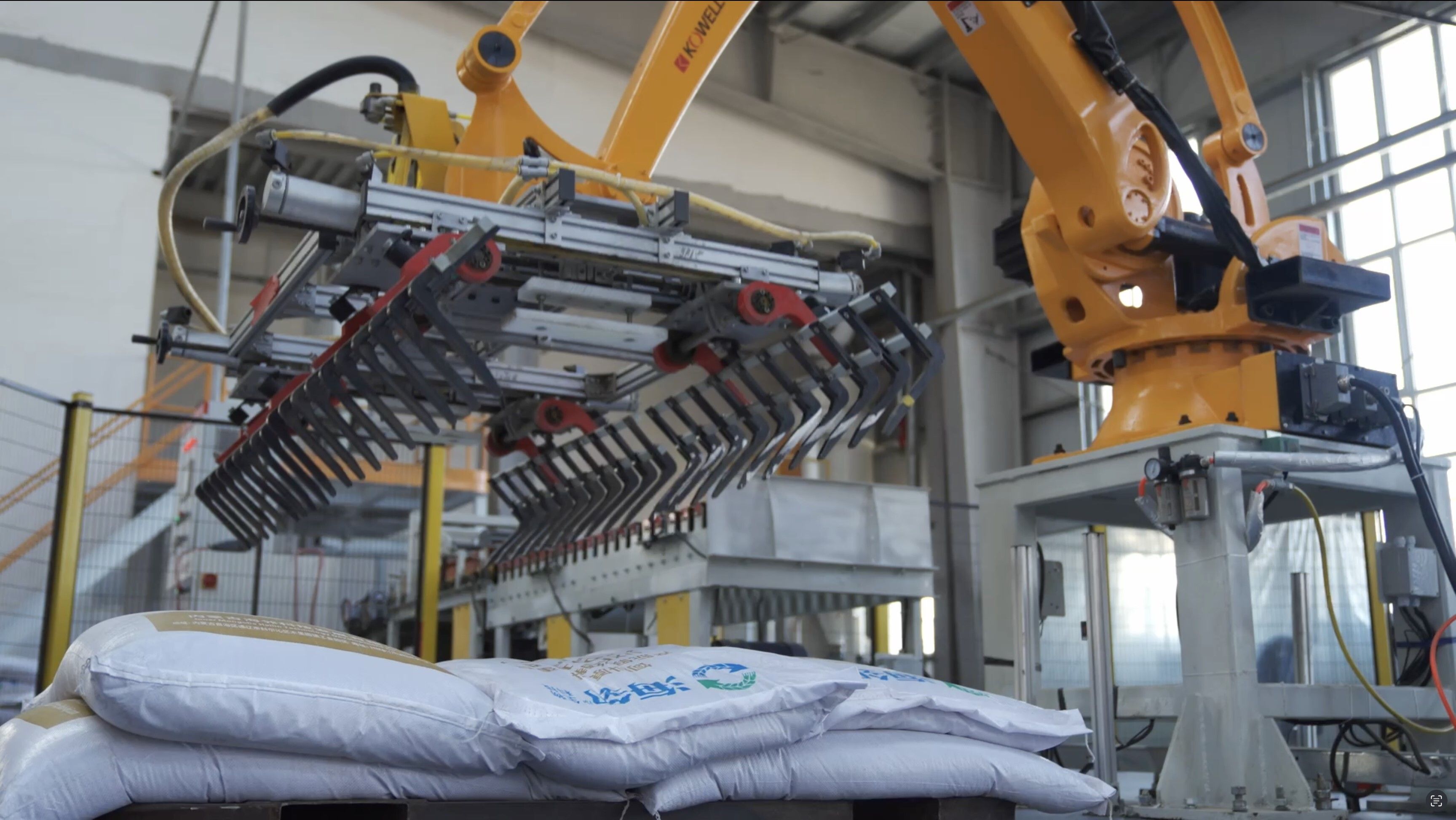 Hailin automated robotic system handling industrial material bags in a modern manufacturing facility.