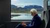 Train passenger with scenic mountain landscape through window. ertms-norway-story-keyvisual