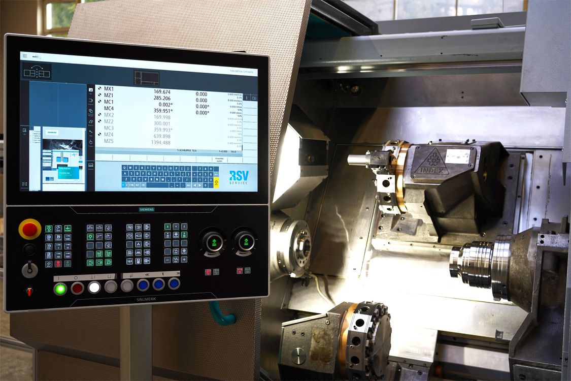 Photo of a machine tool type INDEX G200 with opened work area door, in the foreground the control panel with a CNC type SINUMERIK ONE 