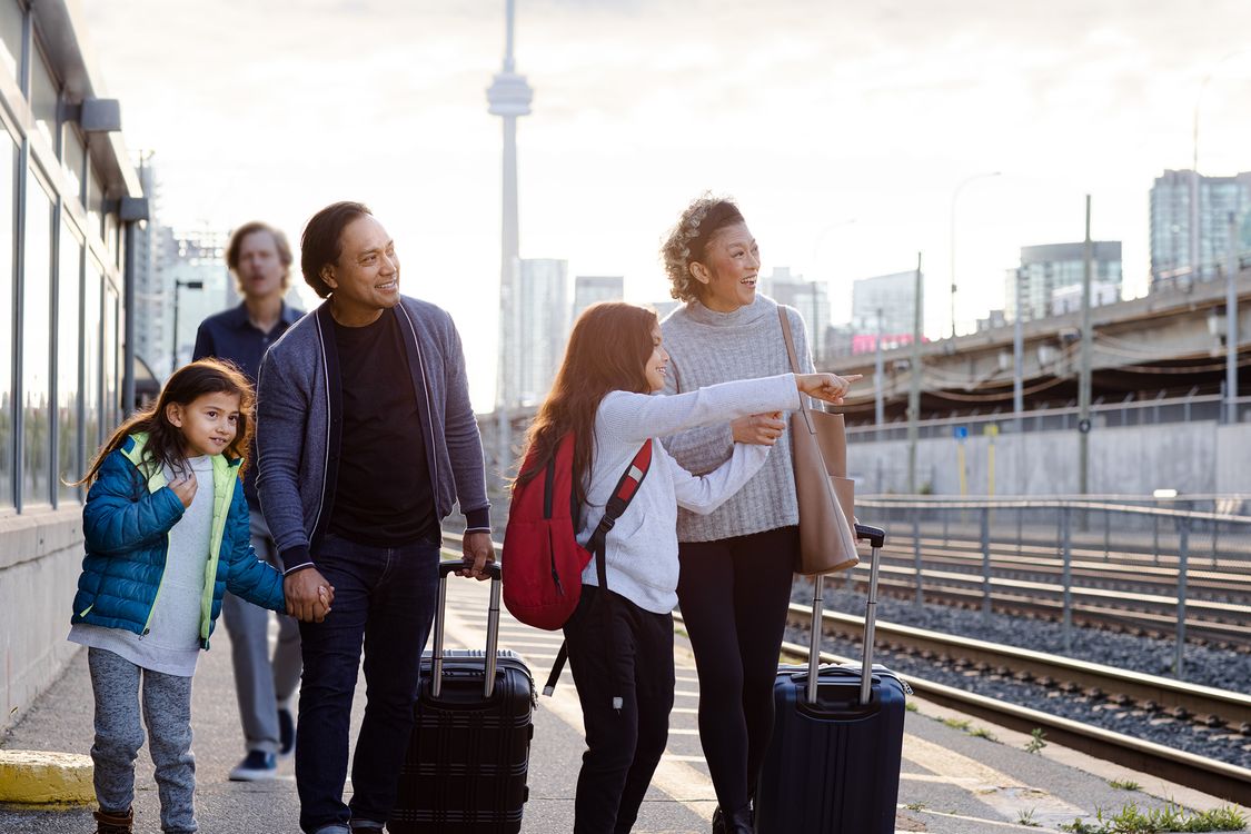Family on train station with the CN tower behind them
