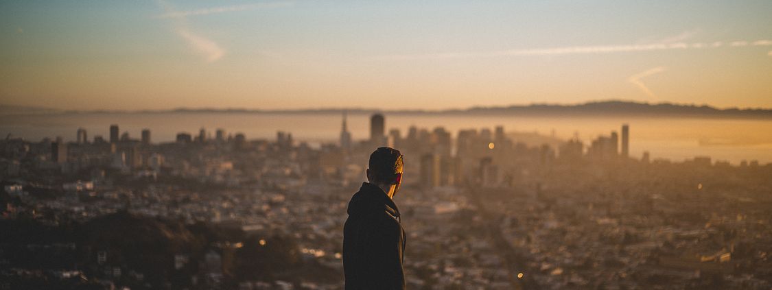 Homem olhando para o horizonte de uma cidade