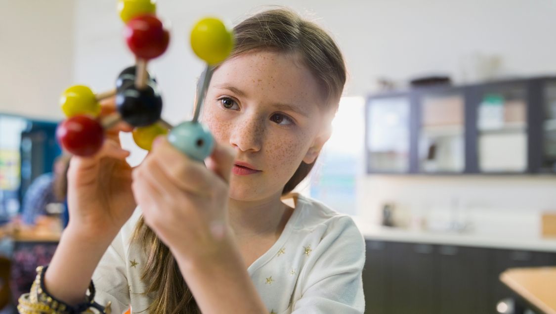 School girl working with colored molecules