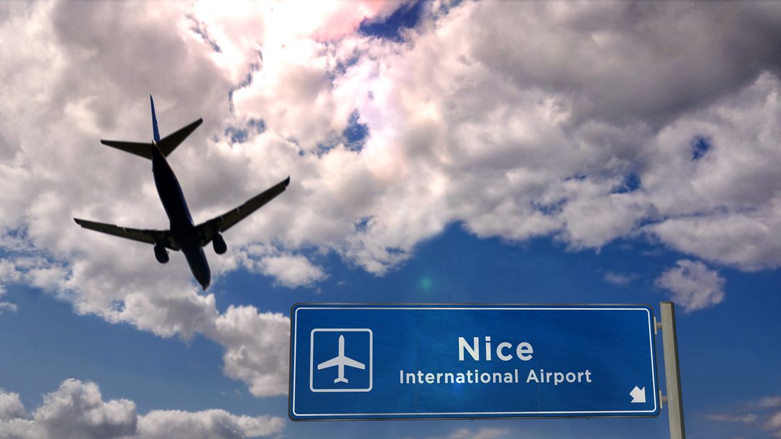 Avion atterrissant à l'aéroport de Nice (France) avec panneau d'affichage