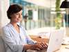 Woman in blue shirt typing on laptop 