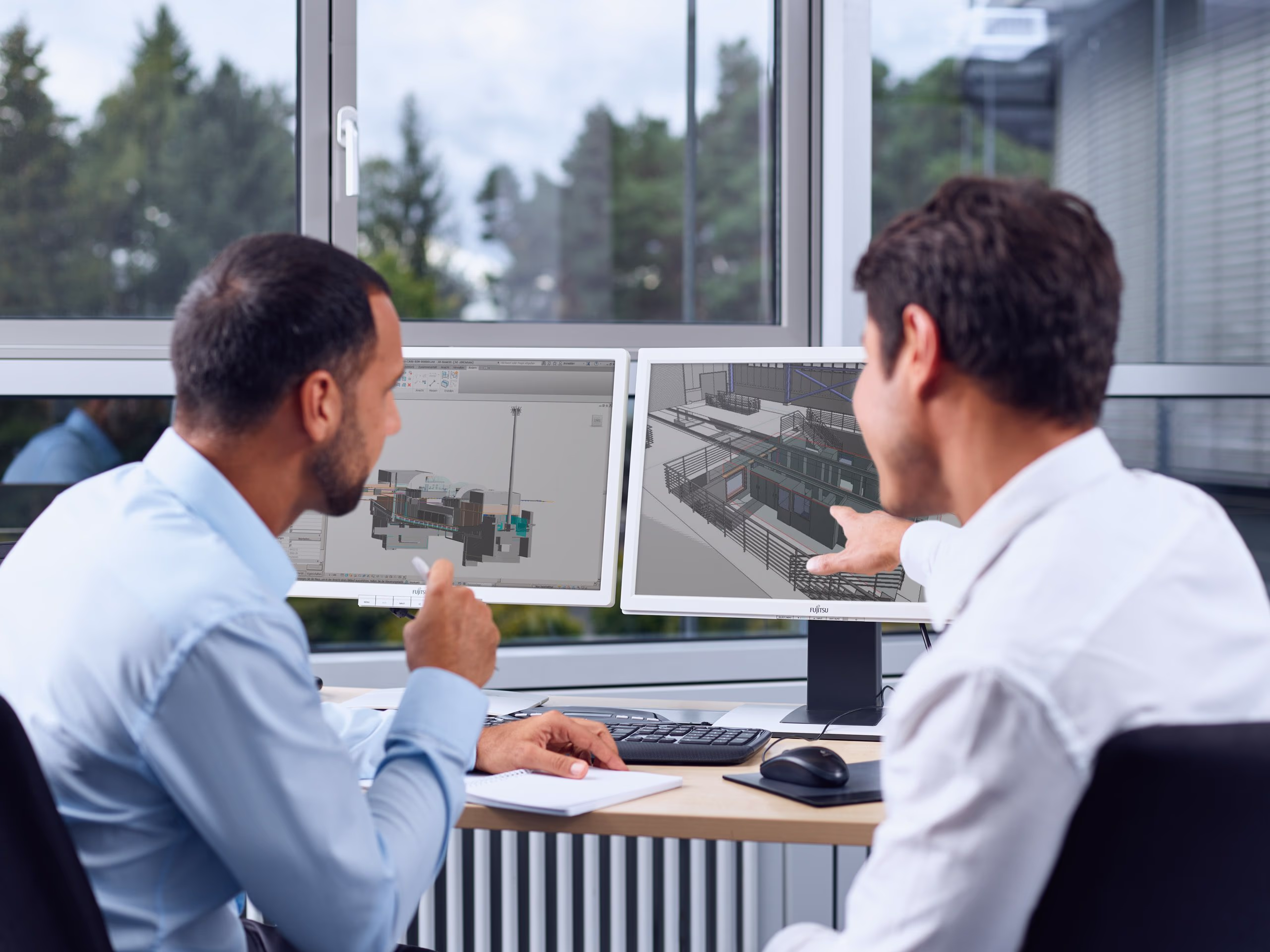 Two engineers looking at a 3D-Model of a rail project System integration