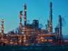 Illuminated oil refinery at dusk, towers and pipes aglow Illuminated oil refinery at dusk, towers and pipes aglow
