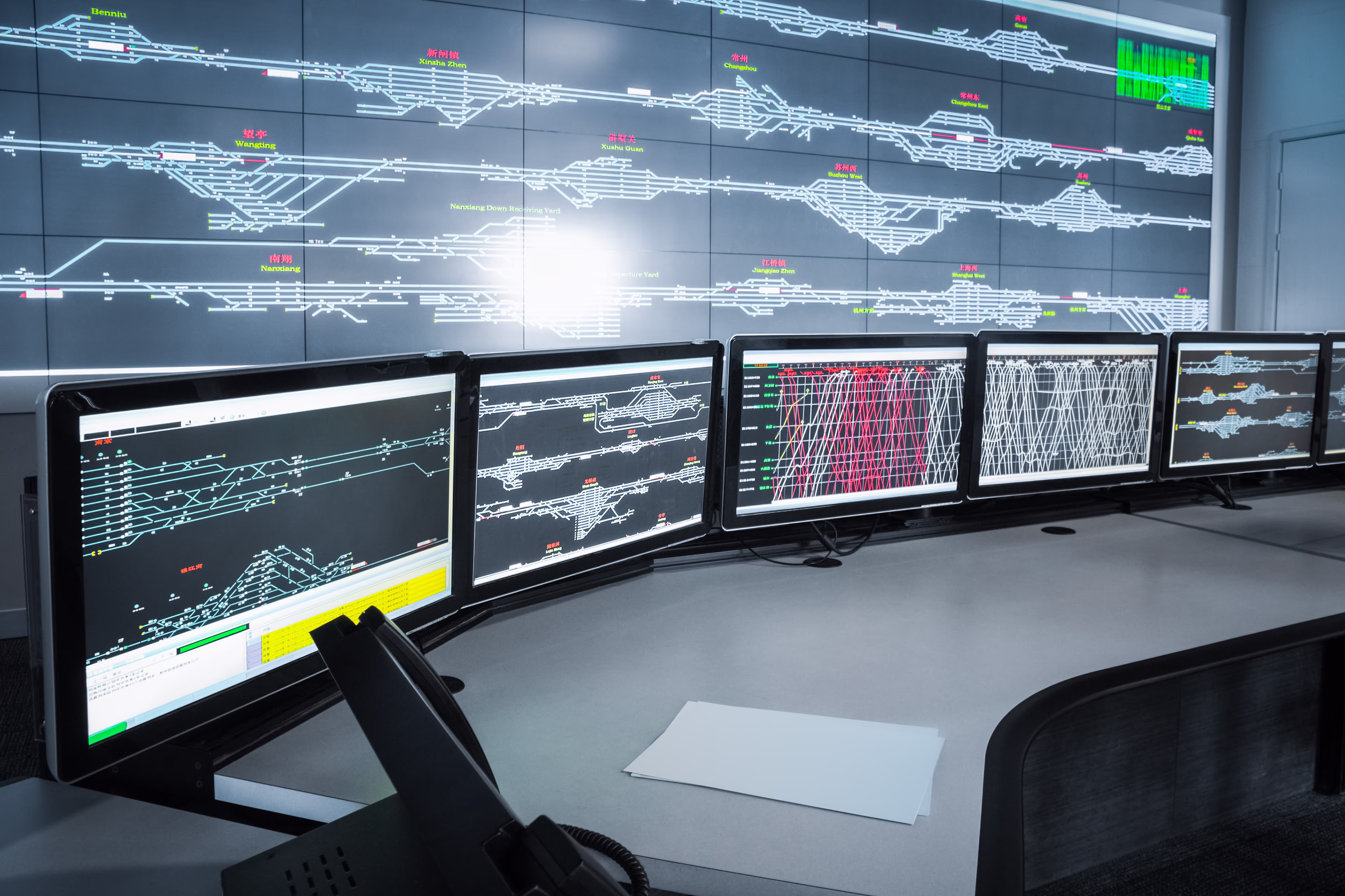A futuristic control center with several monitors showing graphs and interlockings A futuristic control center with several monitors showing graphs and interlockings