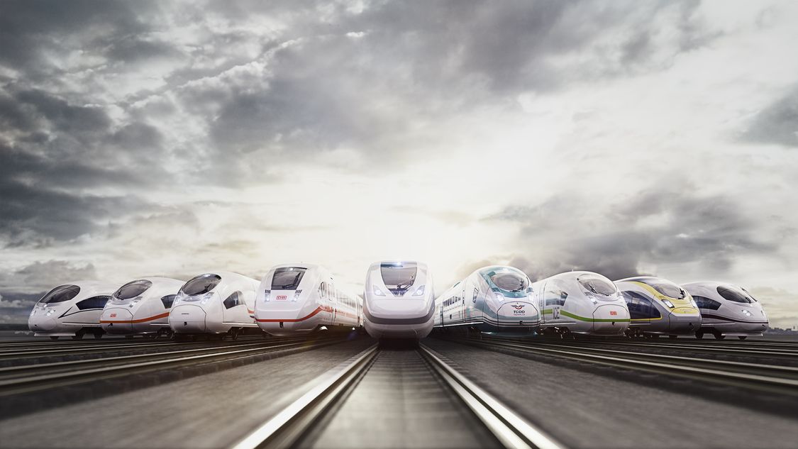 Image of all Siemens Mobility high-speed trains in frontal view, standing side by side on tracks in front of a cloudy sky. 