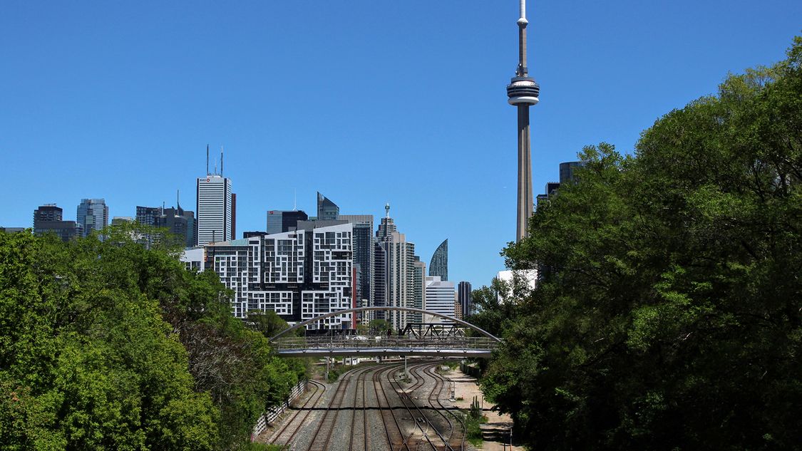 Photo of train tracks leading into Toronto with CN tower in the background