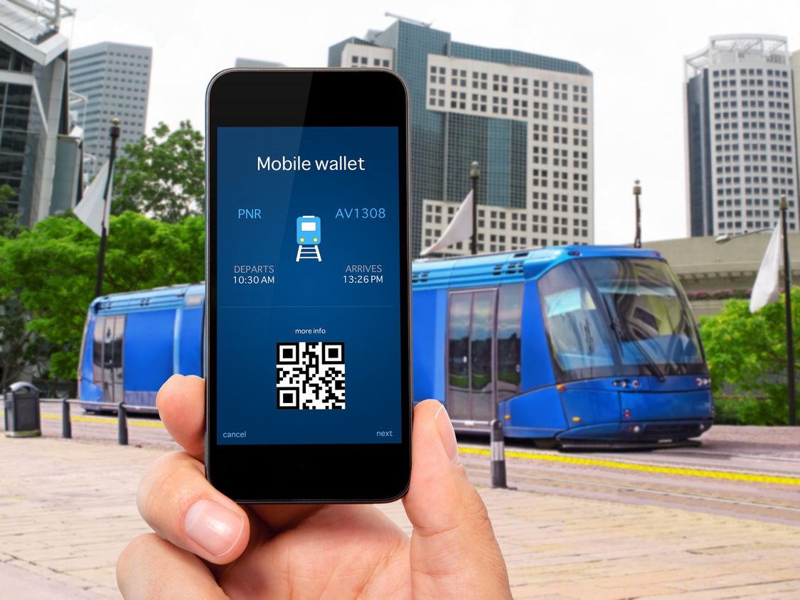 Blick auf Display eines mobile phones und eine blaue Tram