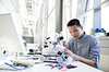 Focused engineer assembling robotic car. Focused engineer assembling robotic car.