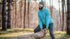 Bärtiger Mann in Sportkleidung hebt im Wald einen Baumstamm an. Bärtiger Mann in Sportkleidung hebt im Wald einen Baumstamm an.