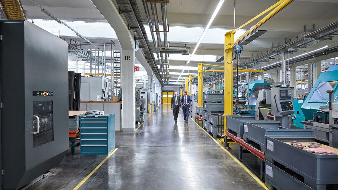 Zwei Personen gehen durch eine Industrieanlage