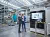 Men looking at machine tool in production plant to discuss service contract