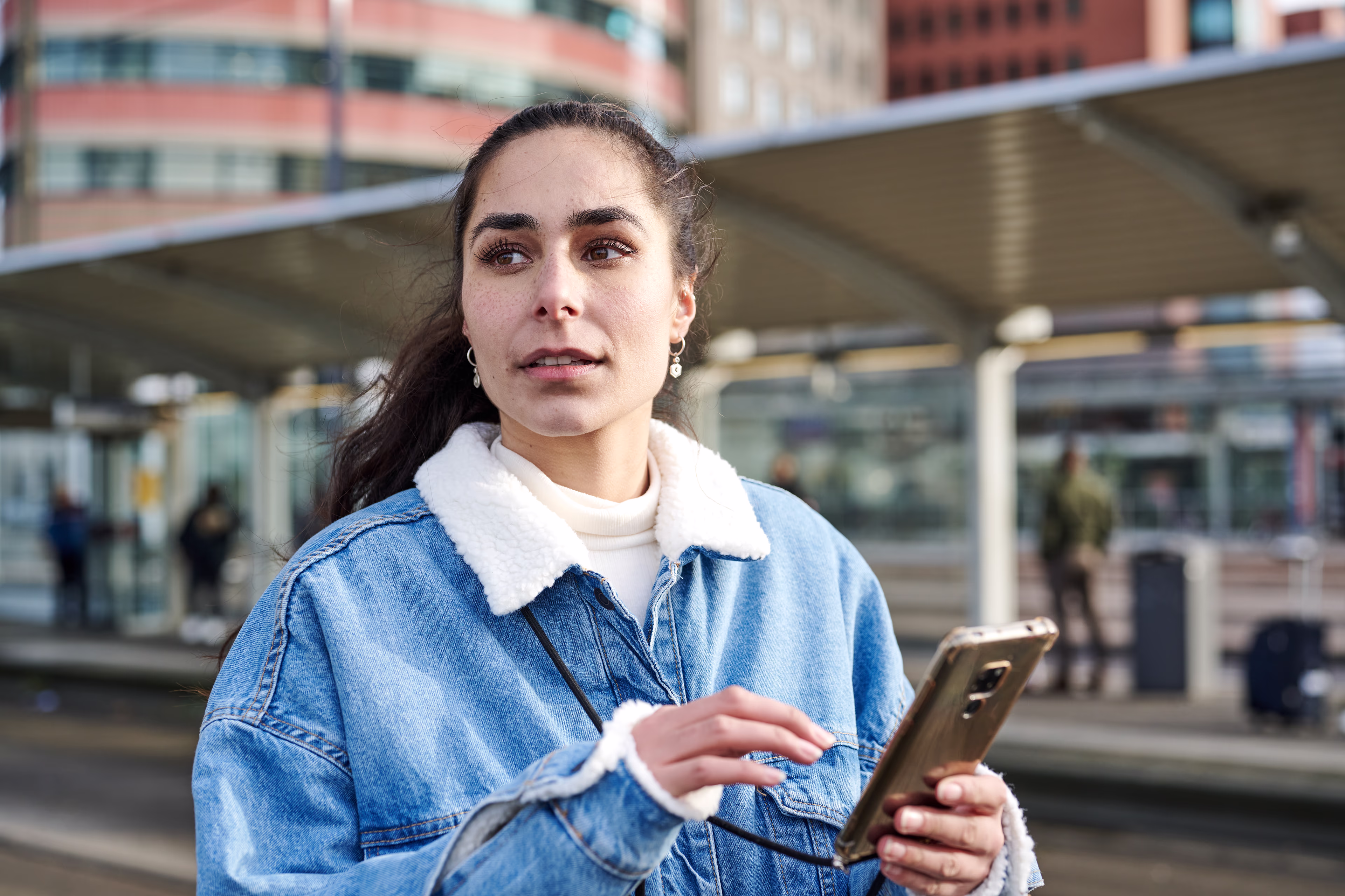 A young woman uses her smartphone to find out about travel options A young woman uses her smartphone to find out about travel options