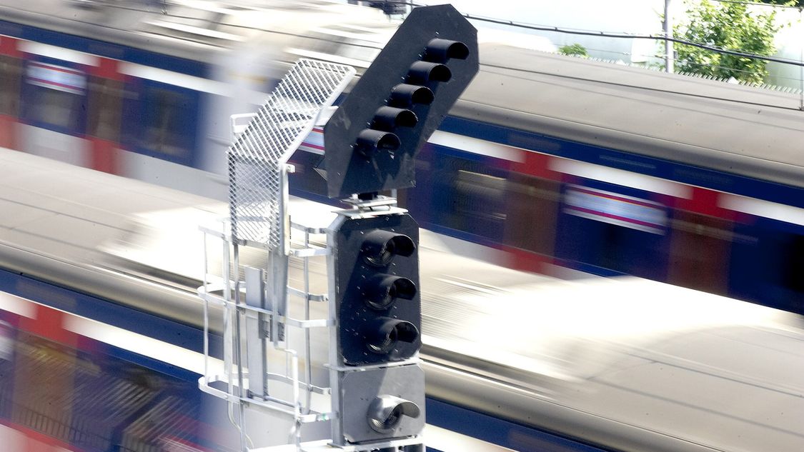 vorbeirassender Zug und ein Signal