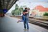 Couple on a train platform hugging 