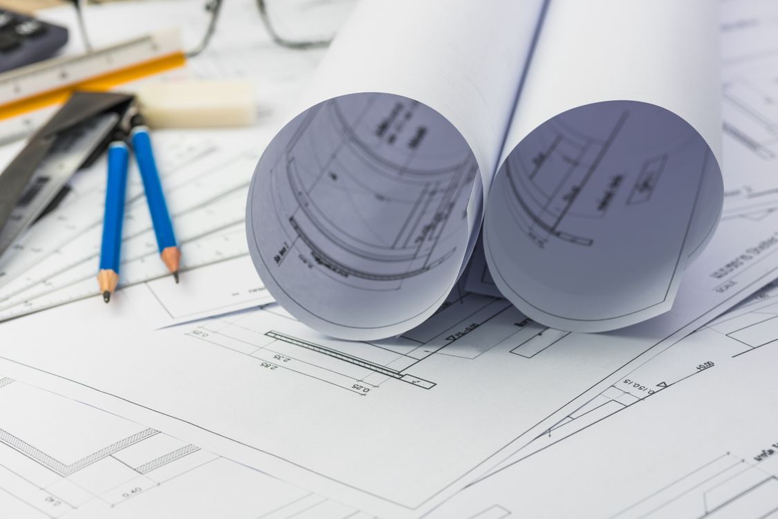 Contact Siemens today. This image shows blueprints and pencils.
