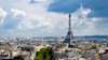 Eiffel Tower rising above Parisian cityscape under cloudy sky paris