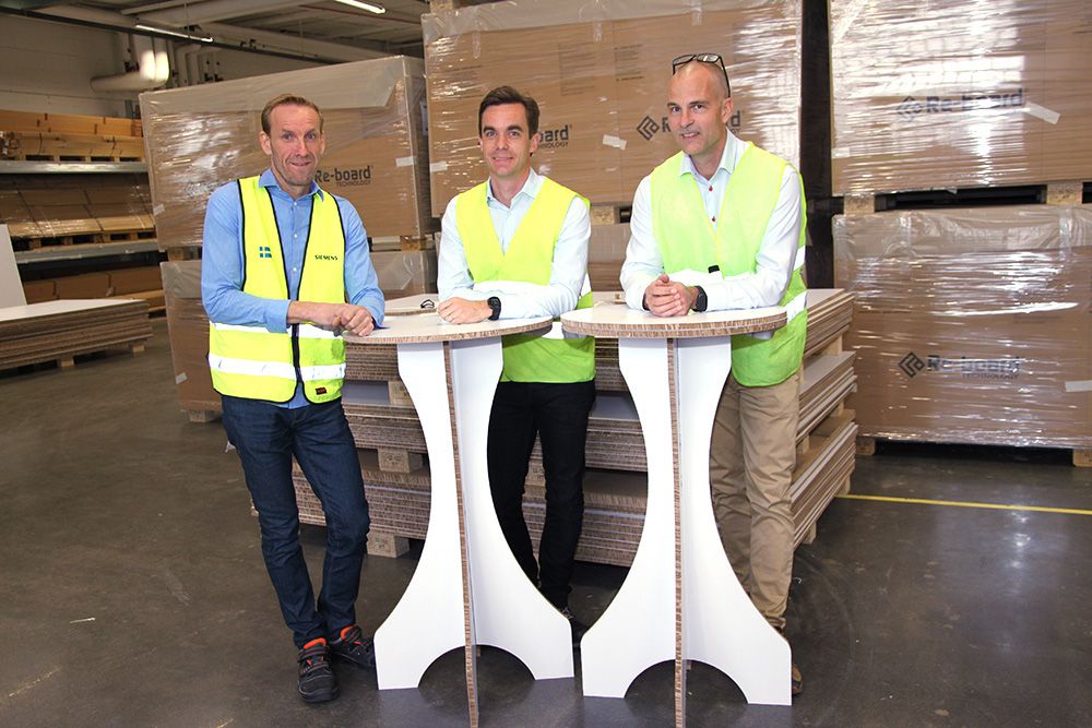 Re-board-skivan klarar såväl vassa som mjuka bockningar och produceras idag framförallt för utställnings- och exponeringsmateriel. 95 procent säljs till reklam- och mässföretag; 200 Re-board-partner runtom i världen jobbar mot olika designer och varumärken. Anders Roos är Account Manager på Siemens, Gustaf Redin är vd på Re-board Technology och John Södersten, då produktionschef på Re-board Technology, är den som har programmerat de båda processlinjerna – en blocklinje och en såg- och lamineringslinje. Papperet kreppas och skärs till 1,5x2 meter stora block som sågas och limmas. Två Simatic S7-1500T-cpu:er styr linjerna.