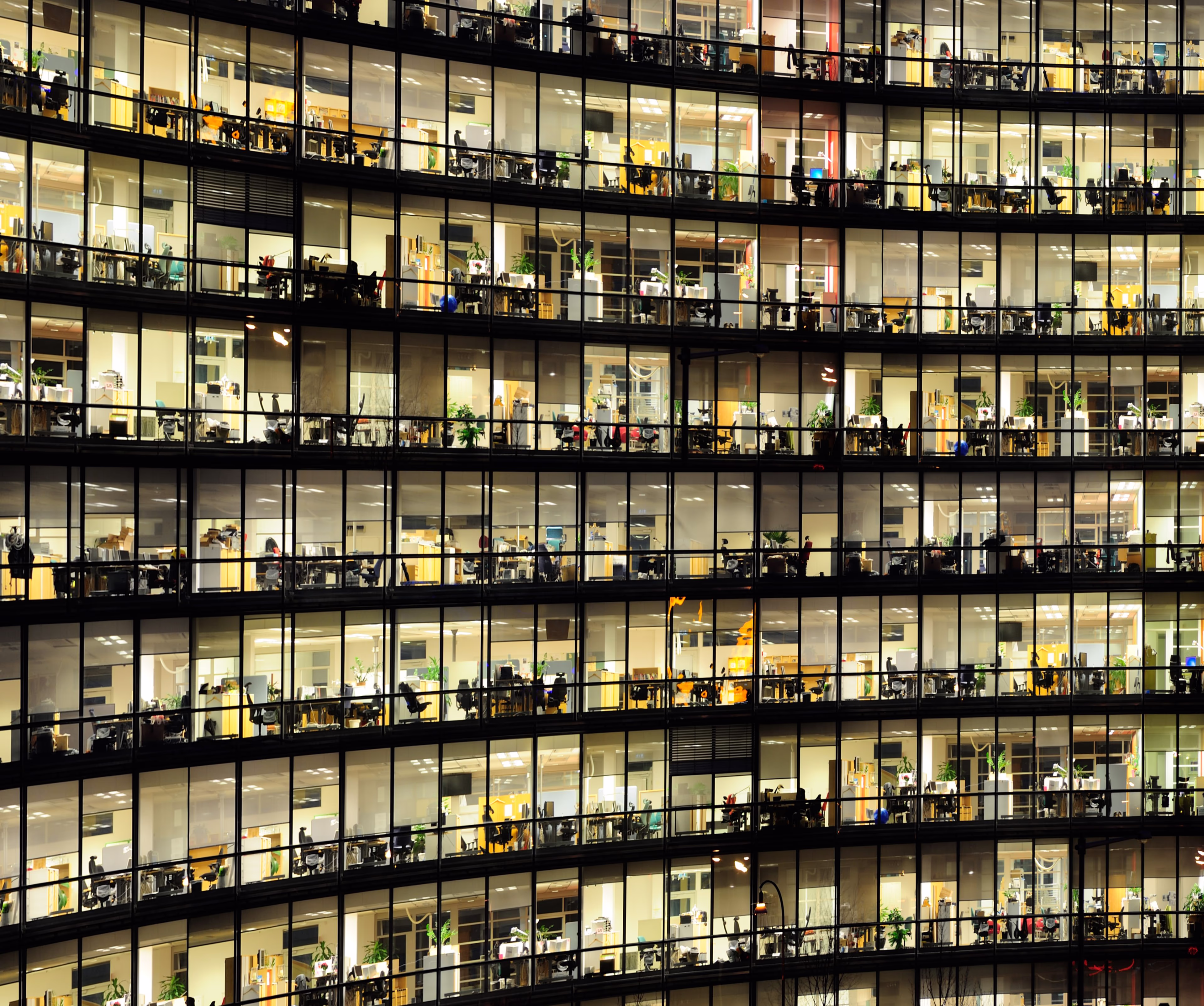 A photo of an office building at night with many illuminated windows. office-building-night