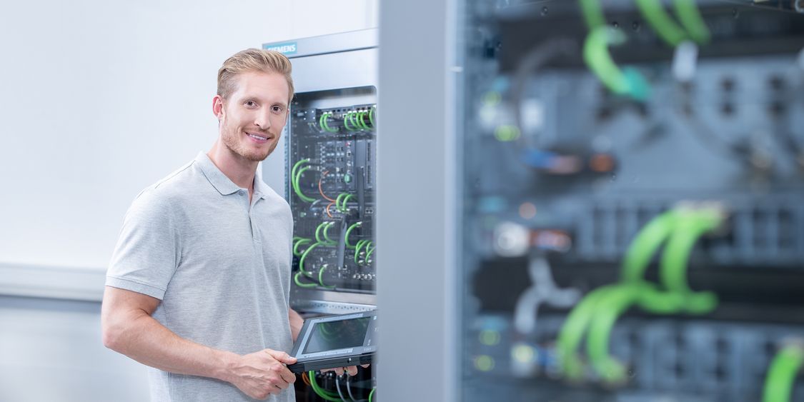 Pracovník manipulující s centrálním řídicím panelem Siemens pro průmyslovou komunikaci podniku