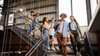 A group of higher Education students walking down the stairs at a library