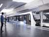 Ein Inspiro Metro Zug von Siemens Mobility hält an einem modernen Metro-Bahnhof. Am Bahnsteig sind Passagiere zu sehen.
