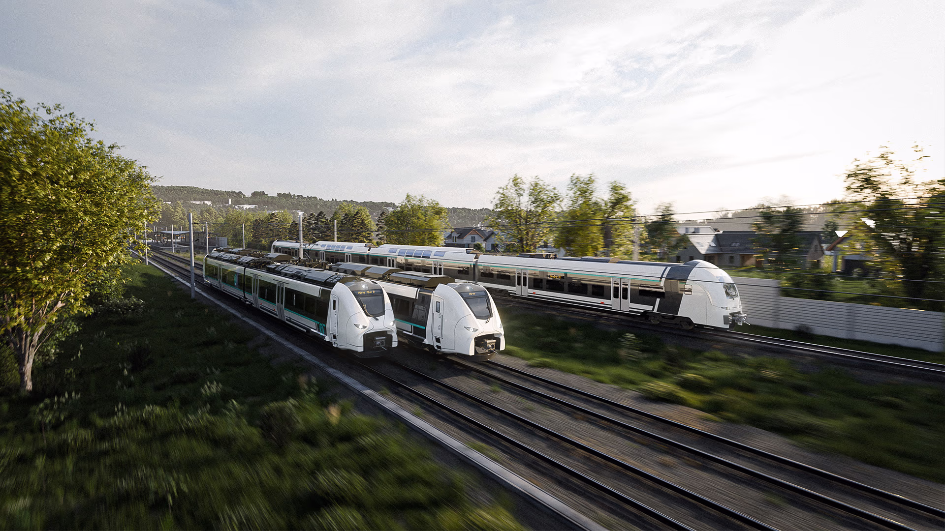 Drei Züge von Siemens Mobility für den Regional- und Nahverkehr fahren an einem Dorf vorbei. Siemens Mobility Commuter- und Regionalzüge