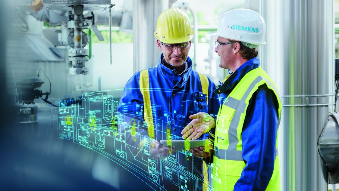 In a chemical plant, two men in working clothes exchange ideas with each other, holding a mobile tablet PC in one hand. Part of the image is a digital layer that shows a typical process flow in virtual form.