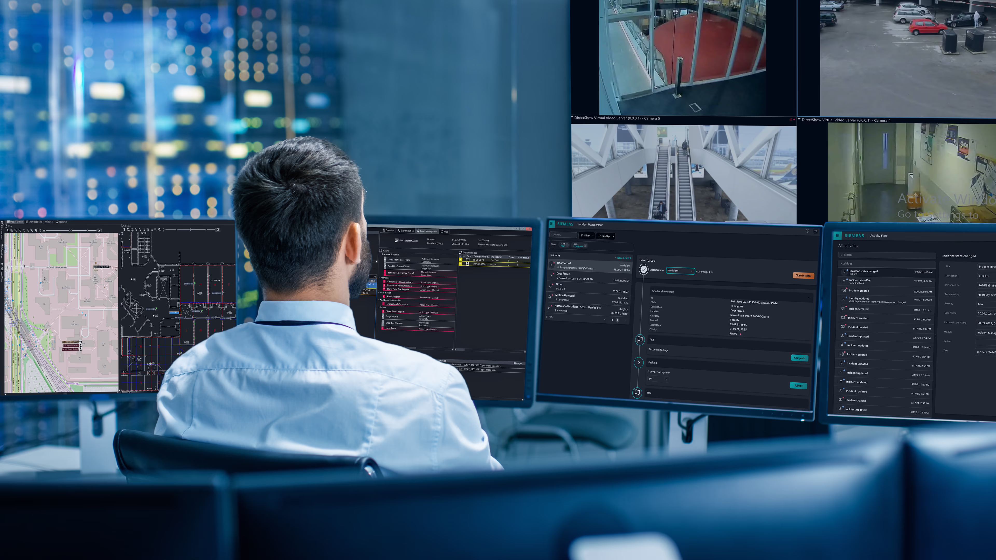 Man is sitting in a control center, watching multiple monitors at the same time