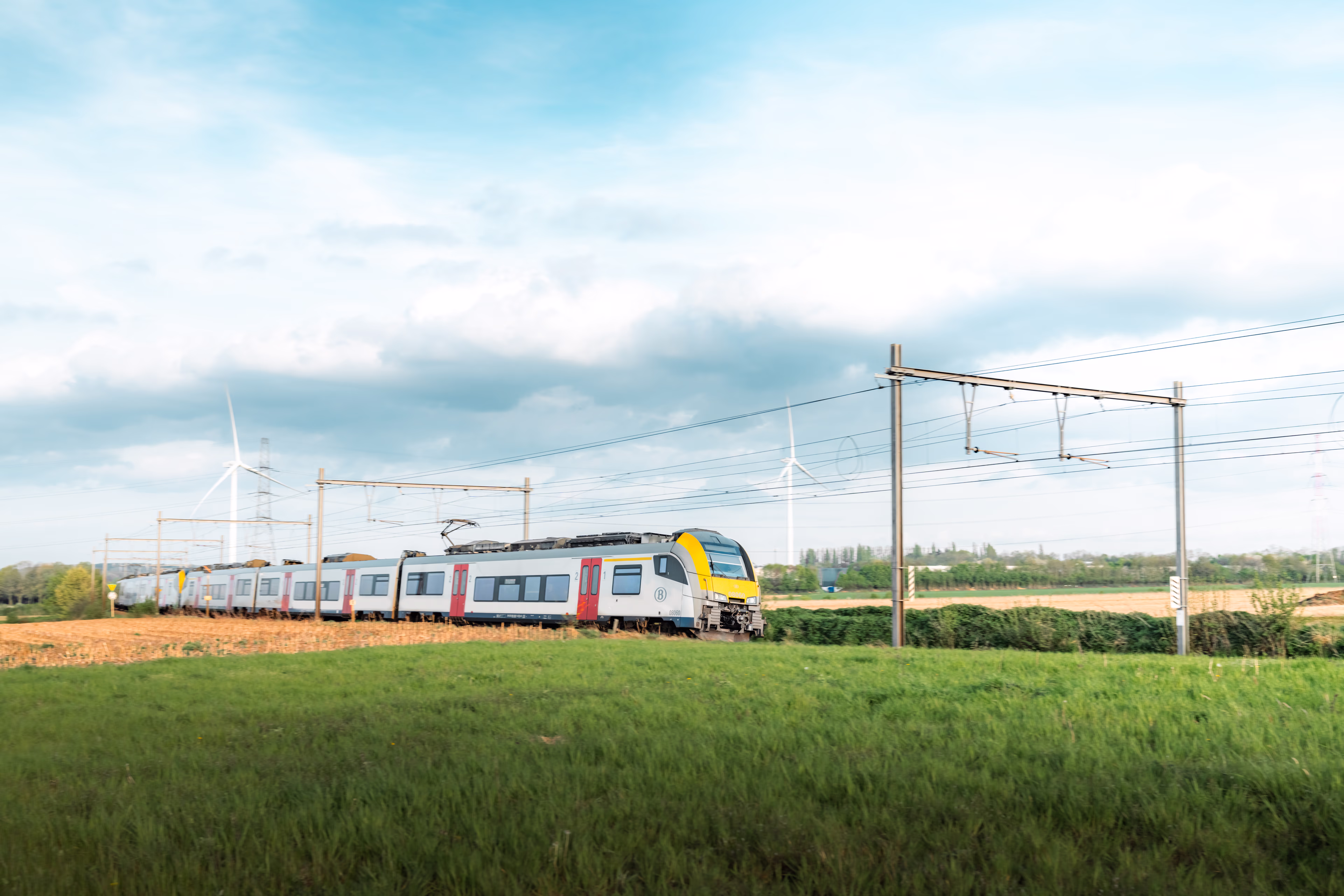 Desiro train passing through countryside, wind turbines in background desiro-train-in-nature