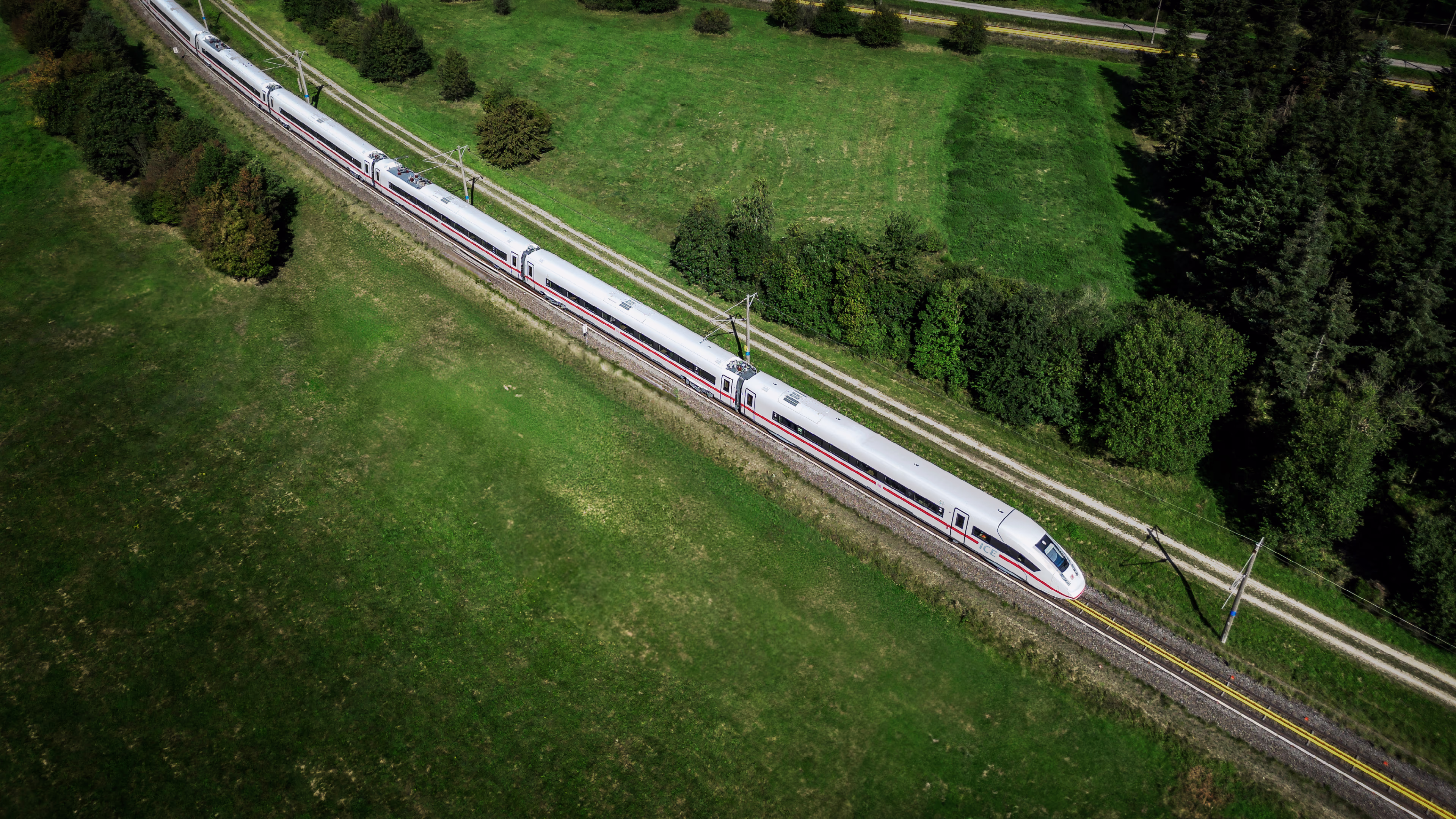 High-speed train curving through lush green countryside system-availability