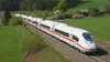 Ein Velaro D von Siemens, der als ICE der Deutschen Bahn auf einer Bahnstrecke zwischen grünen Feldern fährt. 