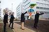 4 Männer werfen Frisbees vor dem Kunstwerk