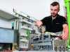 Technician working on electrical equipment at workbench