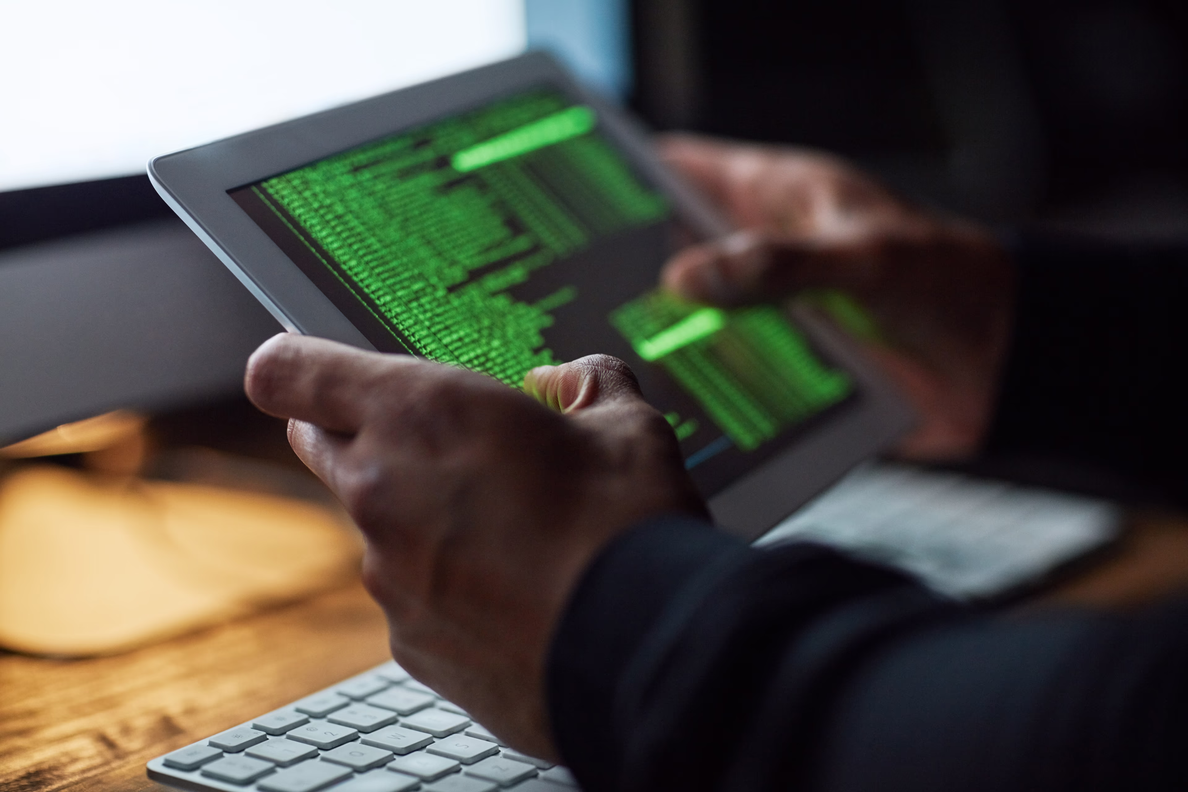 Close-up: Two hands hold a tablet with many lines of code on it. Close-up: Two hands hold a tablet with many lines of code on it.