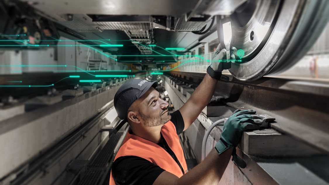 Service technician from Siemens Mobility Rail Services at work beneath a rail vehicle – checks the track wheel